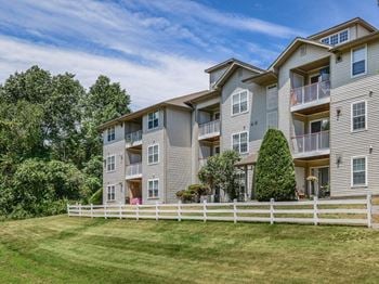 An apartment building with a white fence in front of it